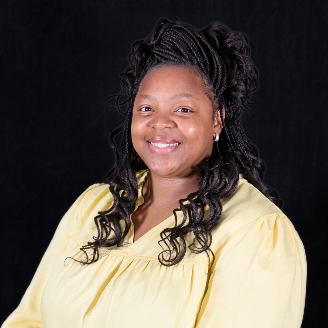 Smiling woman in yellow shirt in front of a black background